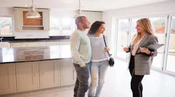 A real estate agent gives buyers a tour of a home.