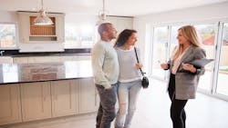 A real estate agent gives buyers a tour of a home. A real estate agent gives buyers a tour of a home.