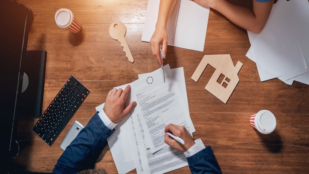 Overhead view of a homebuyer signing a mortgage agreement