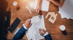 Overhead view of a homebuyer signing a mortgage agreement