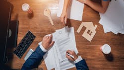Overhead view of a homebuyer signing a mortgage agreement Overhead view of a homebuyer signing a mortgage agreement