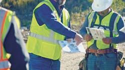 Construction workers go over installation documentation at a jobsite. Construction workers go over installation documentation at a jobsite.