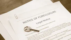 A document reading 'Notice of Foreclosure' with a key sitting on top of it
