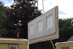 Craning a prefab panel into place on the jobsite Craning a prefab panel into place on the jobsite