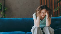 A renter sits on a couch with her head in her hands A renter sits on a couch with her head in her hands