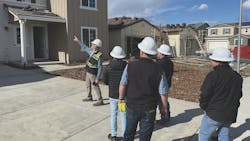 A crew of construction workers inspects the quality of a home under construction A crew of construction workers inspects the quality of a home under construction