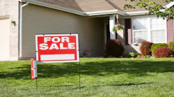 A home with a 'For Sale' sign in the front yard