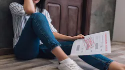 A woman sits on the floor looking over a foreclosure notice