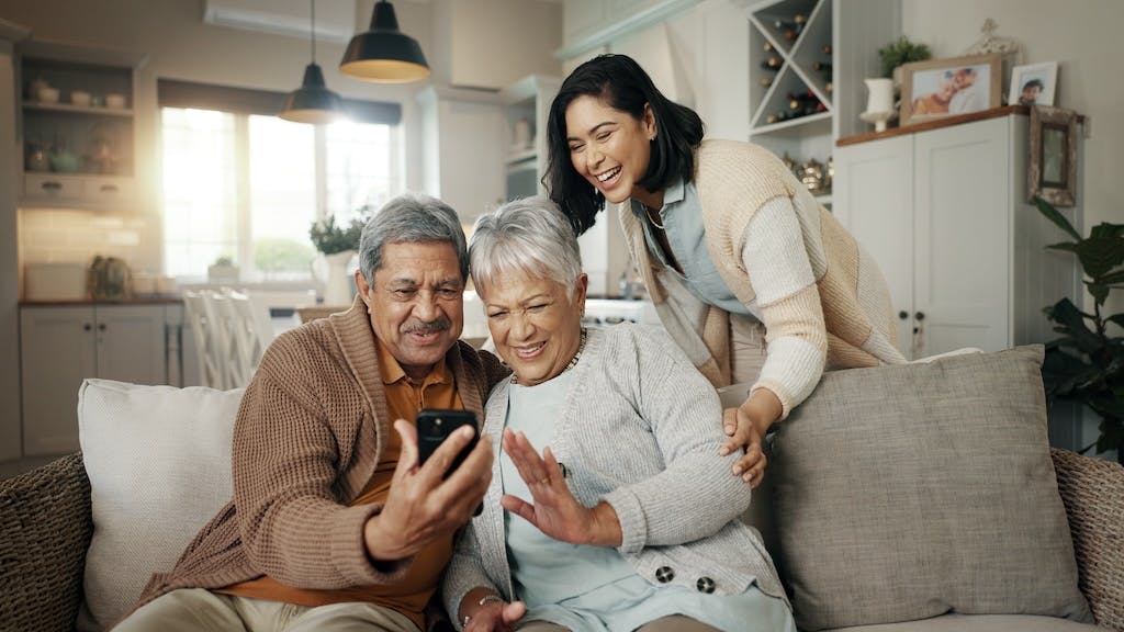 A woman and her parents chat with other family members on a video call