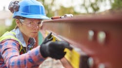 A woman works on a construction jobsite A woman works on a construction jobsite