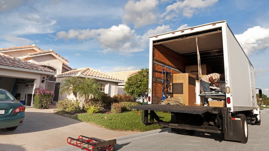 A moving truck parked outside of a home