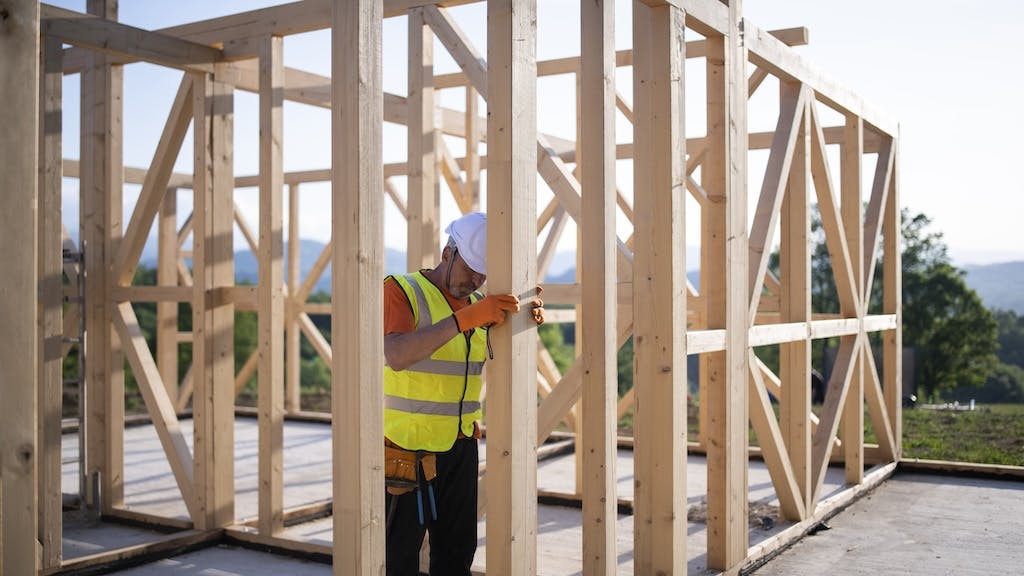 A construction worker erects the framing for a new home.
