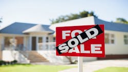 A home with. a 'Sold' sign posted in the front yard A home with. a 'Sold' sign posted in the front yard