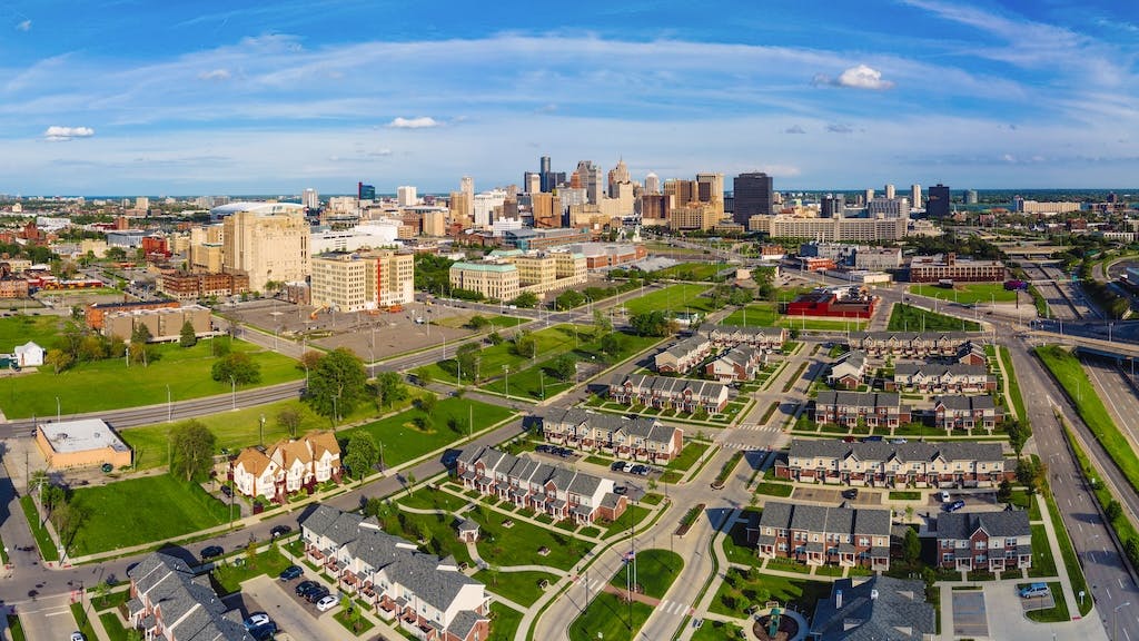 Aerial view of residential neighborhood in Detroit with city skyline in the background