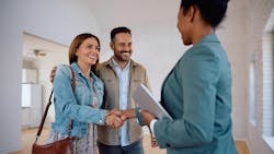 Homebuyers shake hands with a real estate agent who is showing them a home to buy. Homebuyers shake hands with a real estate agent who is showing them a home to buy.