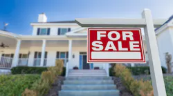 A home with a for sale sign in the front yard