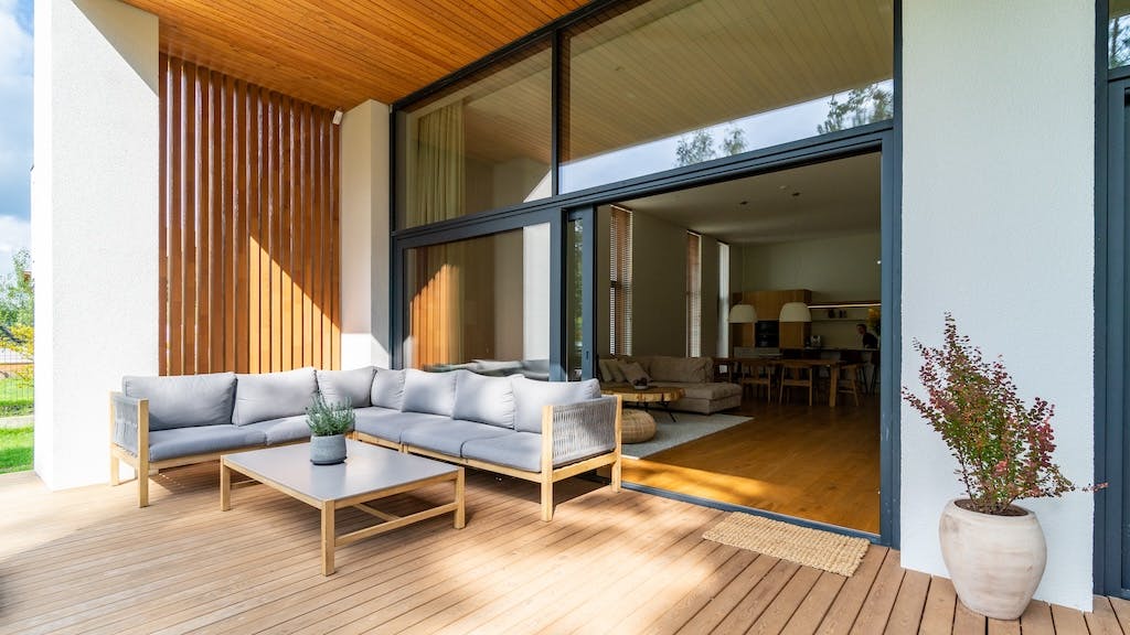 A small patio with a glass door that opens to a living room