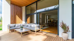 A small patio with a glass door that opens to a living room