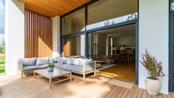 A small patio with a glass door that opens to a living room A small patio with a glass door that opens to a living room