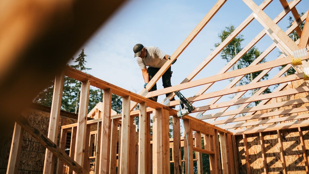 A builder works on framing the roof of a home