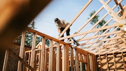 A builder works on framing the roof of a home A builder works on framing the roof of a home