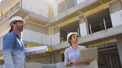 Two construction workers look over their work at a jobsite Two construction workers look over their work at a jobsite