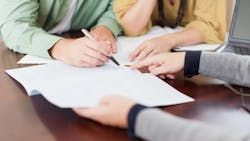 A homebuyer signs a mortgage loan for purchasing their home. A homebuyer signs a mortgage loan for purchasing their home.