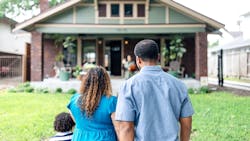 A family stands looking at their front of their home A family stands looking at their front of their home