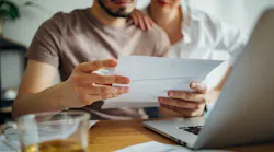 Homeowners appear distressed as they look over their bills