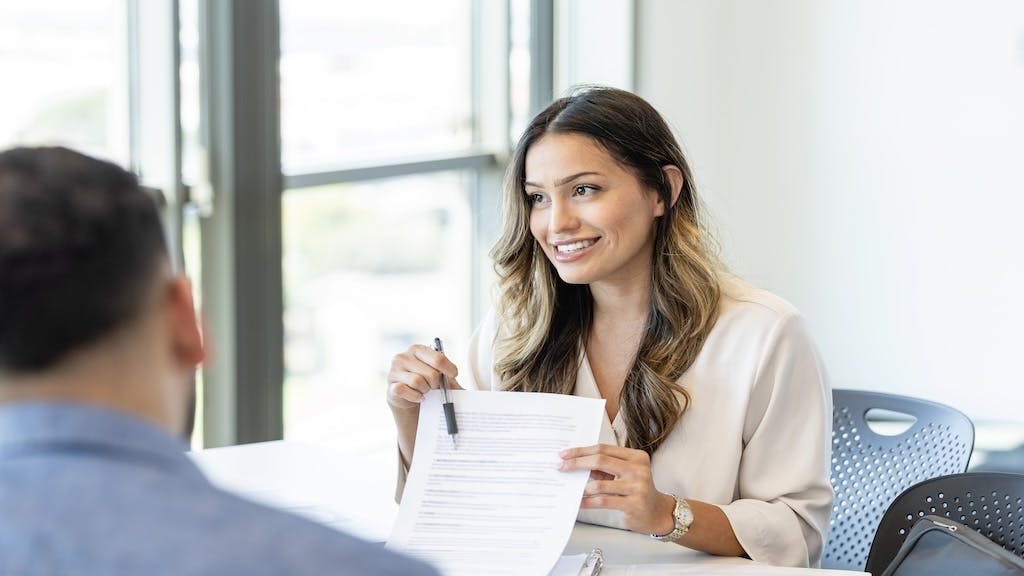 A mortgage broker goes over loan documents with a homebuyer