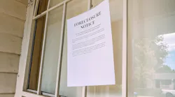 A foreclosure notice taped to the window of a home