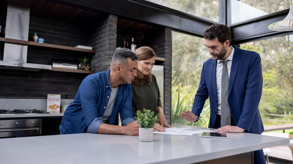 A couple reviews the contract for their home with a real estate agent
