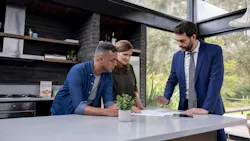 A couple reviews the contract for their home with a real estate agent A couple reviews the contract for their home with a real estate agent