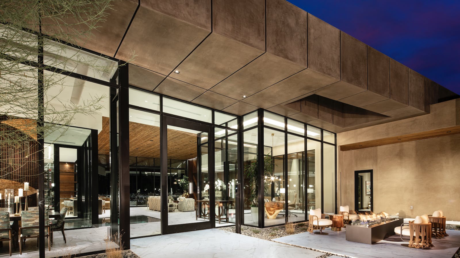 The dramatic entry to The new American Home 2025 with pivoting door and expansive glass window walls