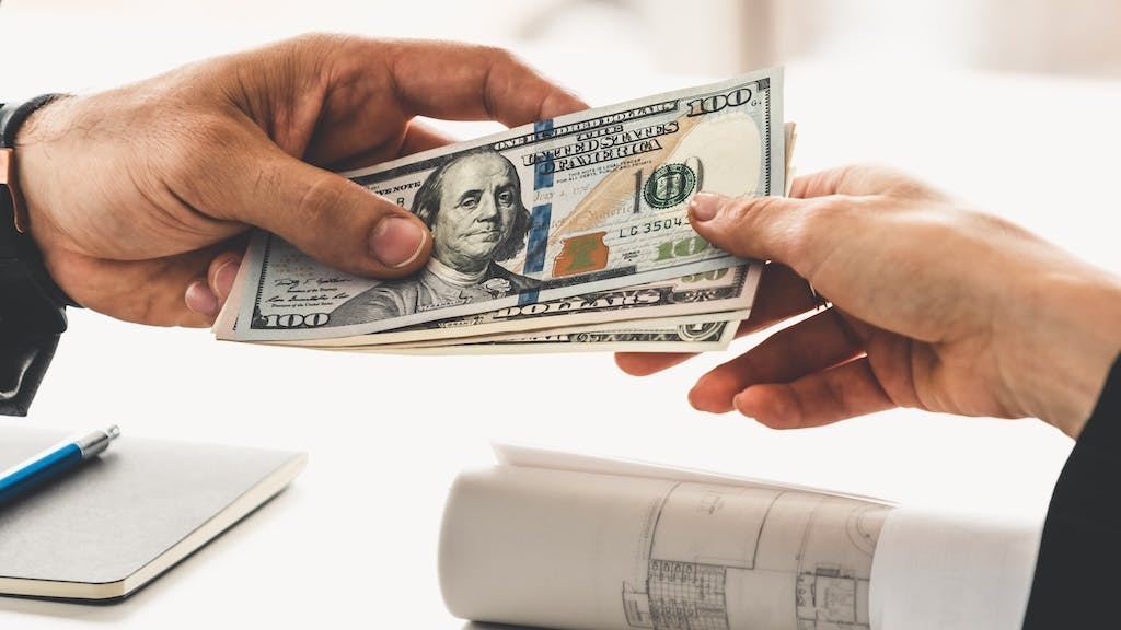 One individual hands money to another individual