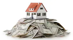 A model home sitting on a pile of money