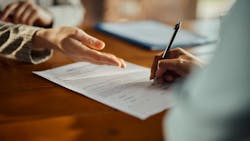 Homebuyer signs mortgage loan application Homebuyer signs mortgage loan application