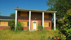 A boarded up suburban home with a foreclosure notice on the windows A boarded up suburban home with a foreclosure notice on the windows