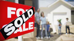 A family moves into a home. A sign in the front yard indicates that the home just sold.