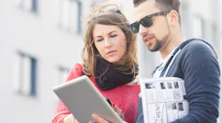 Young couple with rental brochure and iPad search for apartment