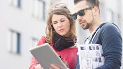 Young couple with rental brochure and iPad search for apartment Young couple with rental brochure and iPad search for apartment