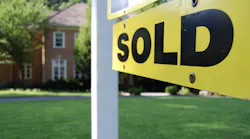 Yellow and black 'Sold' sign in front of an existing home representing the increase in existing home sales prices compared with new-home sales prices