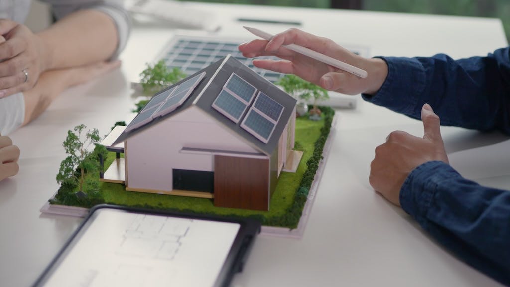 Business professionals look over energy-efficient model home on a table.