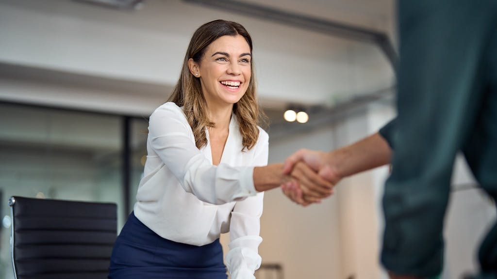An real estate investor shakes hands with another professional after making a deal