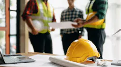 A construction crew looks over plans for a home to ensure they anticipate as many hurdles as possible for a successful project outcome.