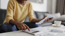 A homeowner goes over her budget on a calculator as homeowner concerns mount about housing affordability.