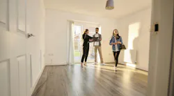 Young homebuyers touring a home with a real estate agent as homeownership rates among younger generations stagnate.