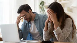 A couple looks stressed as they look over their finances and realize homeownership isn't possible.