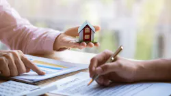 Homebuyers signing papers with a real estate agent for a home sale.