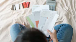 A homeowner goes over her bills as housing costs rise.
